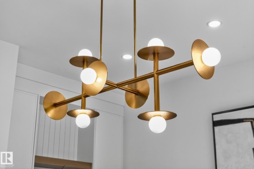 Modern brass chandelier featuring multiple globe lights and disc accents - 13804 85 Avenue, Edmonton, AB - Indoor Photo Showing Other Room