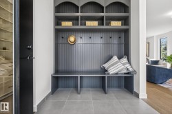 Custom built-in hall tree featuring beadboard paneling, integrated bench seating, multiple storage cubbies, and coat hooks - 