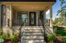Stone facade entry with a full-light door, covered porch, wood-finish ceiling with recessed lighting, and glass panel railings - 13804 85 Avenue, Edmonton, AB  - Outdoor With Deck Patio Veranda 