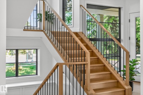 Hardwood staircase featuring wood handrails and black metal balusters - 13804 85 Avenue, Edmonton, AB - Indoor Photo Showing Other Room