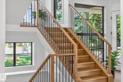 Hardwood staircase featuring wood handrails and black metal balusters - 