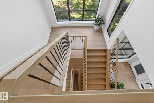 Multi-level light wood staircase featuring black metal balusters and light wood handrails - 13804 85 Avenue, Edmonton, AB - Indoor Photo Showing Other Room