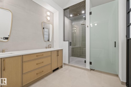 Bathroom featuring a dual vanity with light wood-finish cabinetry, white countertops, and contemporary gold-toned mirrors - 13804 85 Avenue, Edmonton, AB - Indoor Photo Showing Bathroom