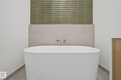 Freestanding bathtub with a fluted exterior, accompanied by wall-mounted brass fixtures - 13804 85 Avenue, Edmonton, AB - Indoor Photo Showing Bathroom