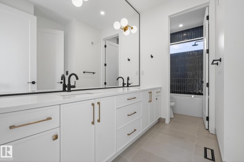 Dual vanity featuring white shaker cabinetry, gold-tone hardware, and matte black fixtures - 13804 85 Avenue, Edmonton, AB - Indoor
