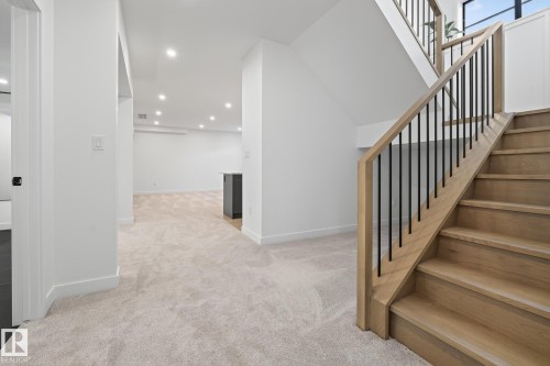 Natural wood staircase with black iron balusters - 13804 85 Avenue, Edmonton, AB - Indoor Photo Showing Other Room