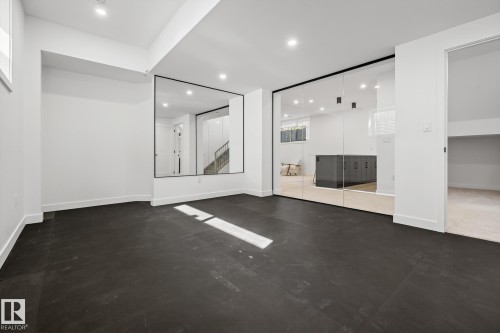 Spacious room featuring dark-toned flooring, white walls, and recessed lighting - 13804 85 Avenue, Edmonton, AB - Indoor Photo Showing Other Room