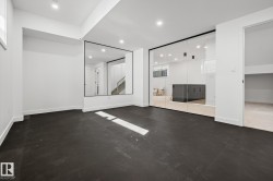 Spacious room featuring dark-toned flooring, white walls, and recessed lighting - 