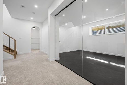 Contemporary interior featuring a glass wall partition, recessed lighting, and a neutral carpeted area - 13804 85 Avenue, Edmonton, AB - Indoor Photo Showing Other Room