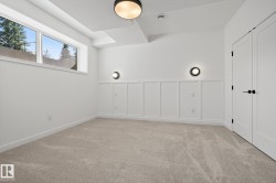 Carpeted interior space featuring white walls and wainscoting - 