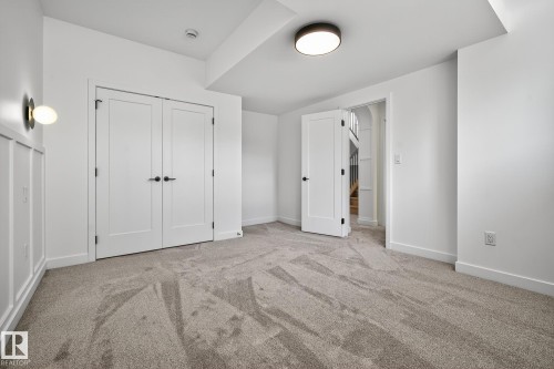 Carpeted room featuring a ceiling-mounted light fixture, recessed smoke detector, and white baseboards - 13804 85 Avenue, Edmonton, AB - Indoor Photo Showing Other Room