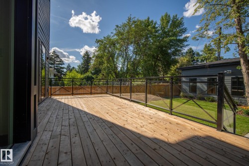 Expansive wood deck with glass panel railing and black metal accents - 13804 85 Avenue, Edmonton, AB - Outdoor With Deck Patio Veranda