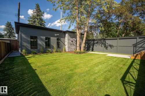 Spacious lawn area framed by a dark-toned privacy fence and mature trees - 13804 85 Avenue, Edmonton, AB - Outdoor