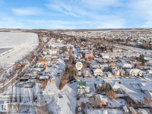 Residential property with a green roof, positioned within a snow-covered urban setting - 5043 48 St Nw, Sylvan Lake, AB - Outdoor With View