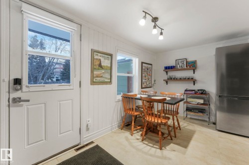 Kitchen dining area featuring light-tone flooring, beadboard wall paneling, and a track light fixture - 5043 48 St Nw, Sylvan Lake, AB - Indoor Photo Showing Other Room