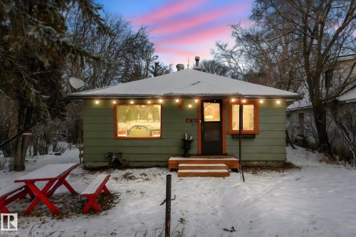 Single-story residence featuring light green siding and a dark roofline - 5043 48 St Nw, Sylvan Lake, AB - Outdoor