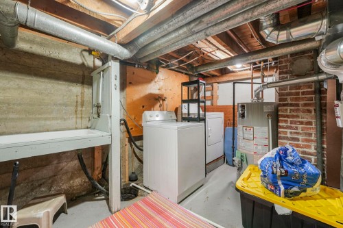 Basement utility area featuring a concrete foundation, exposed ceiling joists, and a brick wall section - 5043 48 St Nw, Sylvan Lake, AB - Indoor Photo Showing Laundry Room