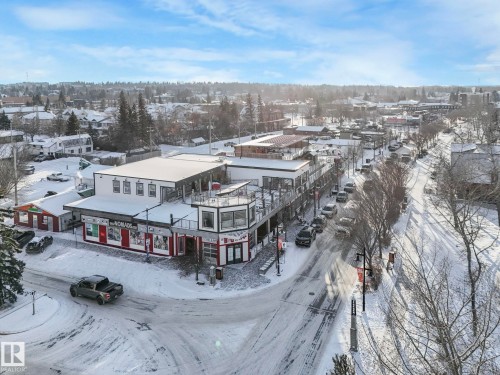 Commercial building with multiple storefronts and upper-level outdoor patio spaces - 5043 48 St Nw, Sylvan Lake, AB - Outdoor With Deck Patio Veranda With View