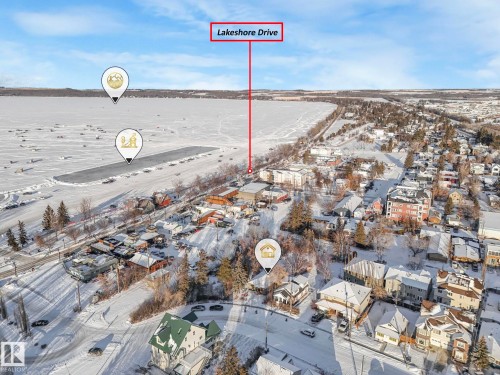 Aerial perspective showcasing a waterfront community with direct street frontage on Lakeshore Drive - 5043 48 St Nw, Sylvan Lake, AB - Outdoor With View
