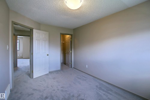 Interior room featuring light gray carpet flooring, neutral wall paint, and a textured ceiling - 8129 7 Avenue, Edmonton, AB - Indoor Photo Showing Other Room