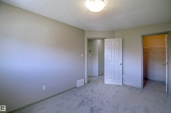 Neutral-toned wall paint and textured ceiling in a carpeted room - 