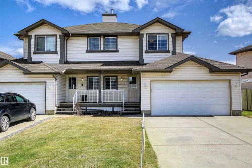 Duplex exterior featuring light-colored siding with dark trim accents - 8129 7 Avenue, Edmonton, AB - Outdoor With Deck Patio Veranda With Facade