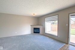Living area featuring light gray walls, textured ceiling, and soft blue carpeting - 