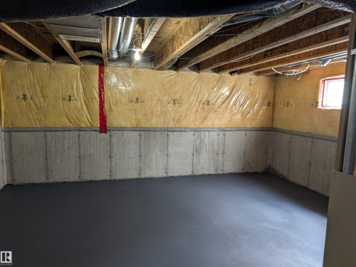 Unfinished basement space featuring concrete walls, exposed ceiling joists, and a poured concrete floor - 8129 7 Avenue, Edmonton, AB - Indoor Photo Showing Basement
