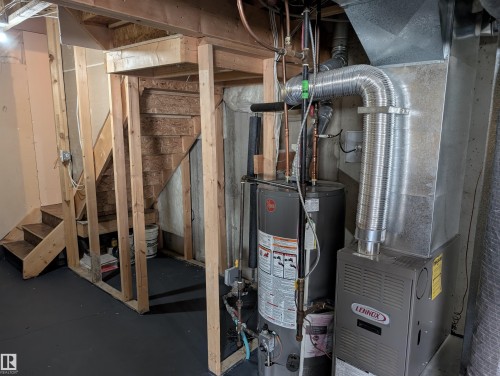 Unfinished basement area featuring exposed wood framing, a Lennox furnace, and a Rheem water heater - 8129 7 Avenue, Edmonton, AB - Indoor Photo Showing Basement