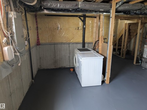 Unfinished basement offering exposed framing, concrete foundation walls, and a painted concrete floor - 8129 7 Avenue, Edmonton, AB - Indoor Photo Showing Basement