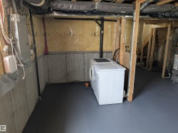Unfinished basement offering exposed framing, concrete foundation walls, and a painted concrete floor - 