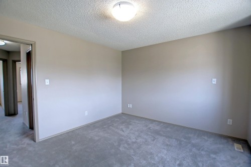 Neutral-toned room with gray carpet flooring, flush mount ceiling light, and white baseboards - 8129 7 Avenue, Edmonton, AB - Indoor Photo Showing Other Room