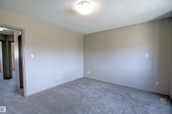 Neutral-toned room with gray carpet flooring, flush mount ceiling light, and white baseboards - 