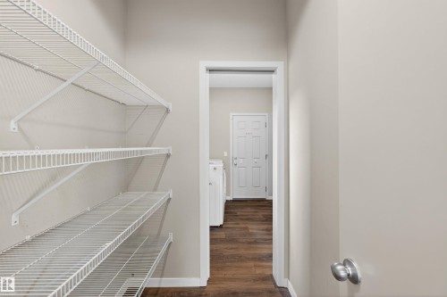 Utility area with ample wire shelving, wood-finish flooring, and neutral wall paint - 4723 Alwood Bend Sw, Edmonton, AB - Indoor With Storage
