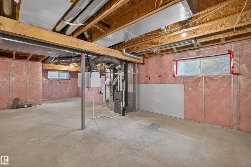 Unfinished basement featuring exposed wood joists, pink insulation, and concrete flooring - 4723 Alwood Bend Sw, Edmonton, AB - Indoor Photo Showing Basement