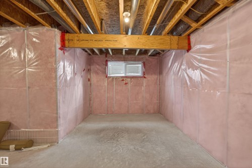 Unfinished basement space featuring exposed wood joists, structural beam, concrete flooring, and insulated walls with vapor barrier - 4723 Alwood Bend Sw, Edmonton, AB - Indoor Photo Showing Basement