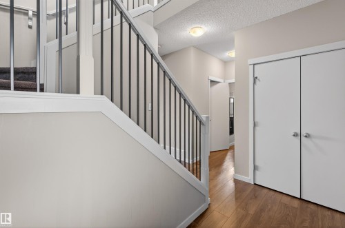 Staircase with dark metal balusters and white trim - 4723 Alwood Bend Sw, Edmonton, AB - Indoor Photo Showing Other Room