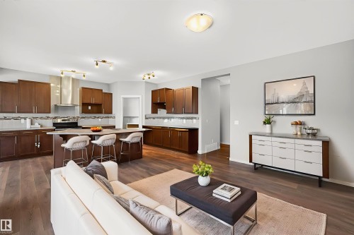 Open-concept kitchen and living area featuring wood-finish flooring, recessed lighting, and a neutral color palette - 4723 Alwood Bend Sw, Edmonton, AB - Indoor