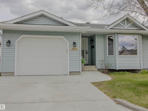 Light blue horizontal siding exterior with a single-car garage, concrete driveway, and front entryway - 5935 189 Street, Edmonton, AB - Outdoor