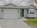 Light blue horizontal siding exterior with a single-car garage, concrete driveway, and front entryway - 5935 189 Street, Edmonton, AB  - Outdoor 