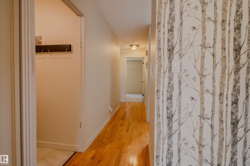 Warm wood-finish flooring extends through the hallway - 5935 189 Street, Edmonton, AB - Indoor