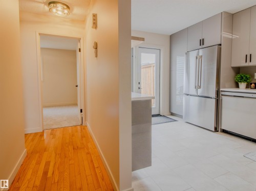 Modern kitchen featuring sleek grey cabinetry, stainless steel appliances, and light tile flooring - 5935 189 Street, Edmonton, AB - Indoor Photo Showing Kitchen