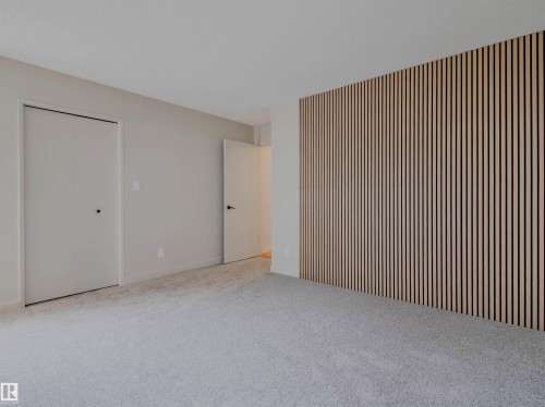 Accent wall featuring vertical wood paneling - 5935 189 Street, Edmonton, AB - Indoor Photo Showing Other Room