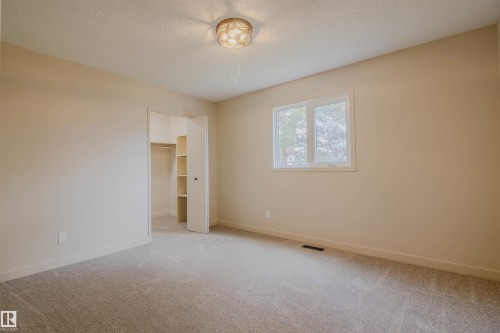 Carpeted room with a double-pane window, flush-mount ceiling light, and neutral wall tones - 5935 189 Street, Edmonton, AB - Indoor Photo Showing Other Room