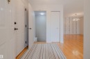 Welcoming entryway featuring hardwood flooring, a white paneled entrance door, and a discrete closet - 5935 189 Street, Edmonton, AB  - Indoor Photo Showing Other Room 