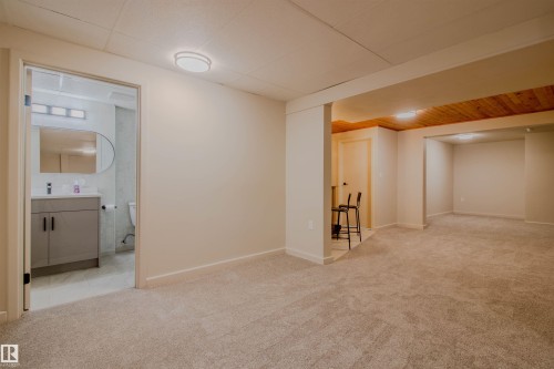 Expansive carpeted area with recessed lighting and a wood-panel accent ceiling - 5935 189 Street, Edmonton, AB - Indoor