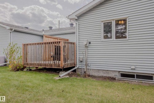 Outdoor wooden deck with privacy screening, featuring a green lawn and light gray siding exterior - 5935 189 Street, Edmonton, AB - Outdoor With Deck Patio Veranda With Exterior