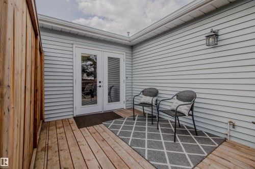 Outdoor deck featuring wood plank flooring and a wood privacy fence - 5935 189 Street, Edmonton, AB -  With Exterior