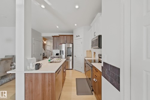 Modern kitchen featuring wood-finish flooring and recessed lighting - 1231 Watt Drive, Edmonton, AB - Indoor Photo Showing Kitchen With Stainless Steel Kitchen With Double Sink