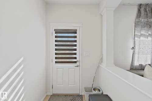 Entry door featuring a privacy blind and light-colored paneled construction - 1231 Watt Drive, Edmonton, AB - Indoor Photo Showing Other Room